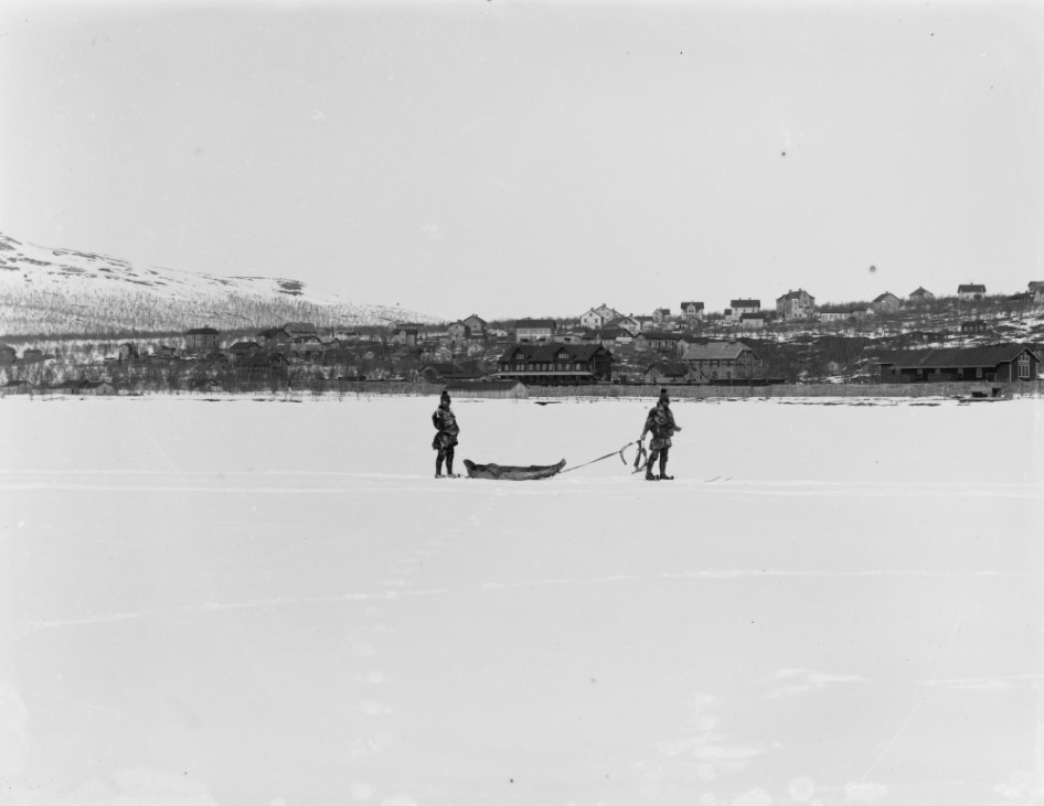 Två samer på väg över Luossajärvi med Kiruna i bakgrunden. År 1904 /Fotograf Borg Mesch