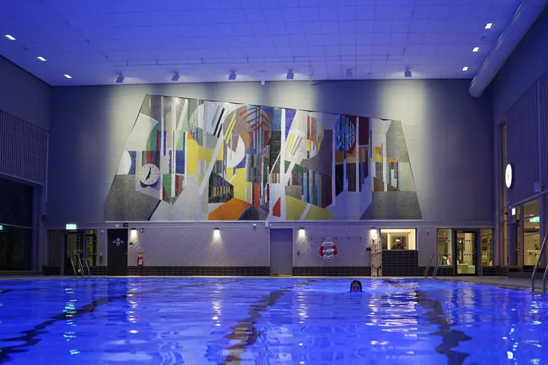 En stor swimmingpool med en stor målning på väggen.